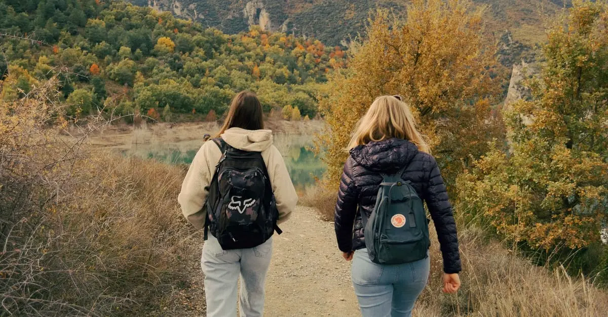 Dos personas caminando por un sendero de otoño